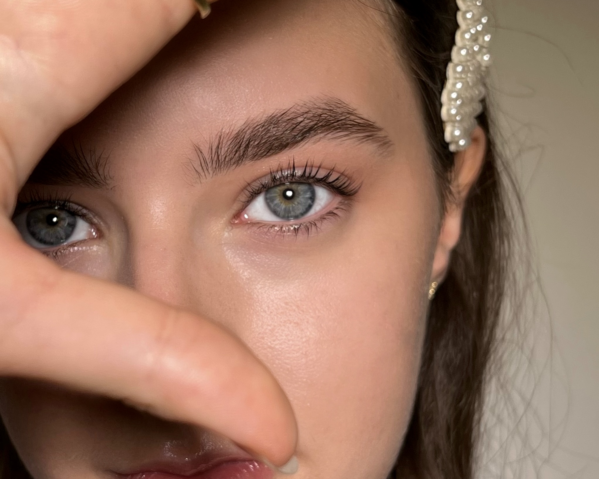 Elegantes Brow und Lash Styling - blaue Augen mit Perlen-Accessoire